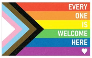 Progress Pride flag design with a triangular chevron on the left, featuring colors for transgender and marginalized communities. On the right, the text reads "Everyone is welcome here" with a small heart at the bottom right.